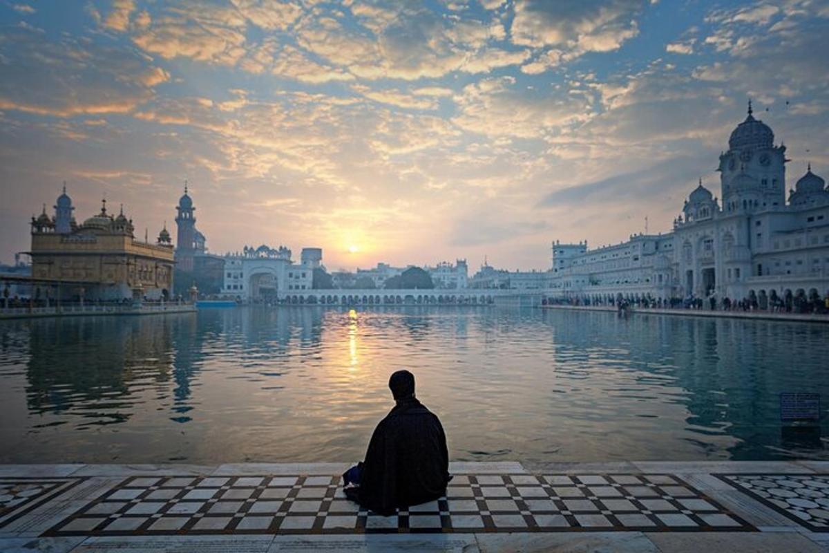a man sitting on a bench in front of a lake