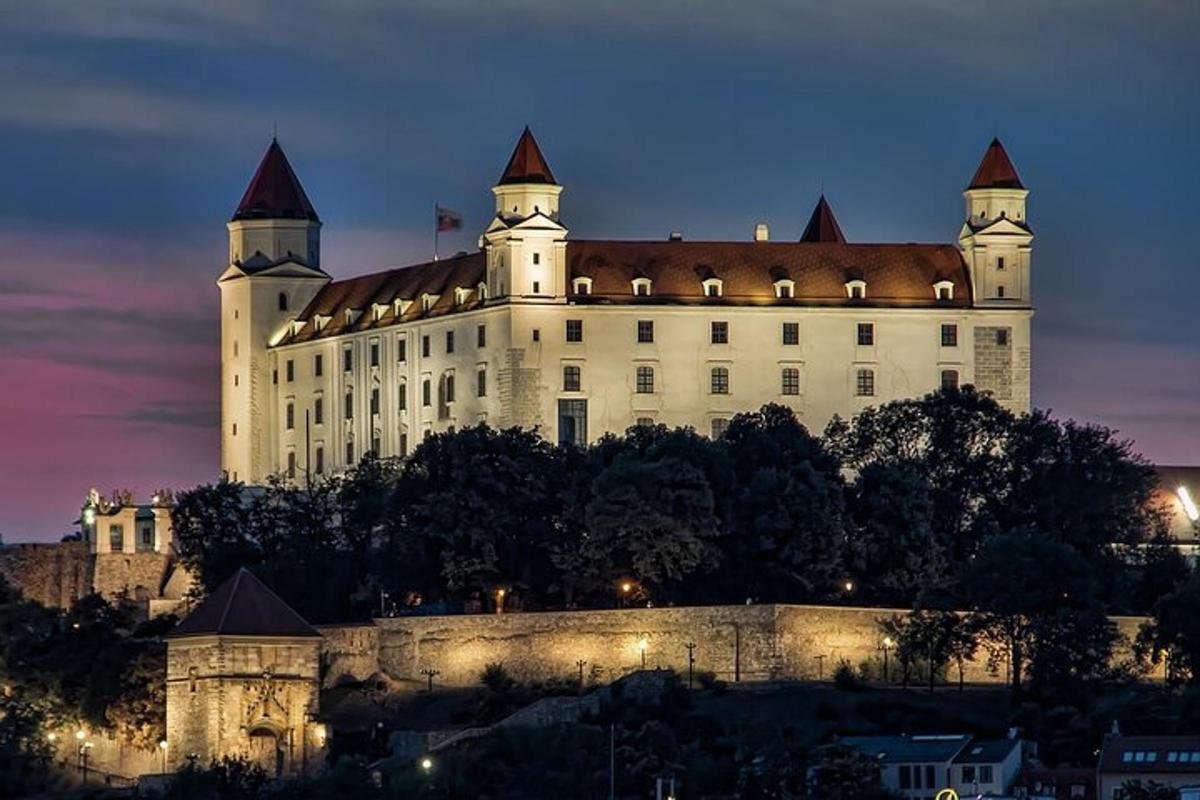 hrad stojící v noci na vrcholu kopce