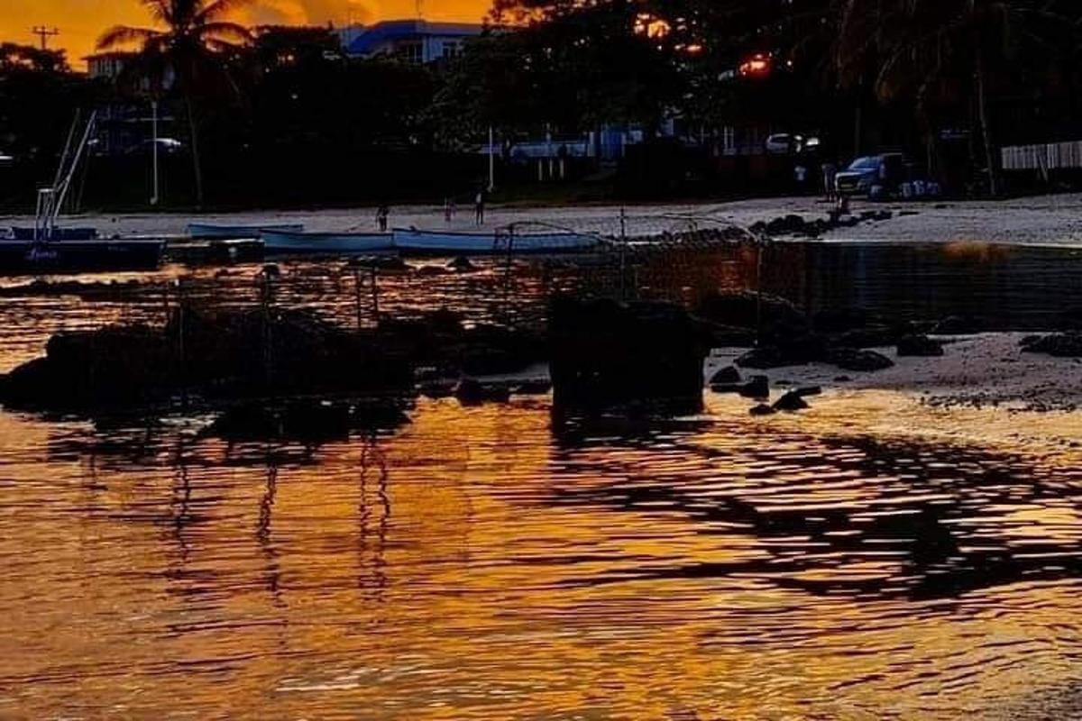 a body of water with a sunset in the background