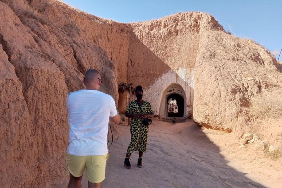two men standing in a tunnel in a desert