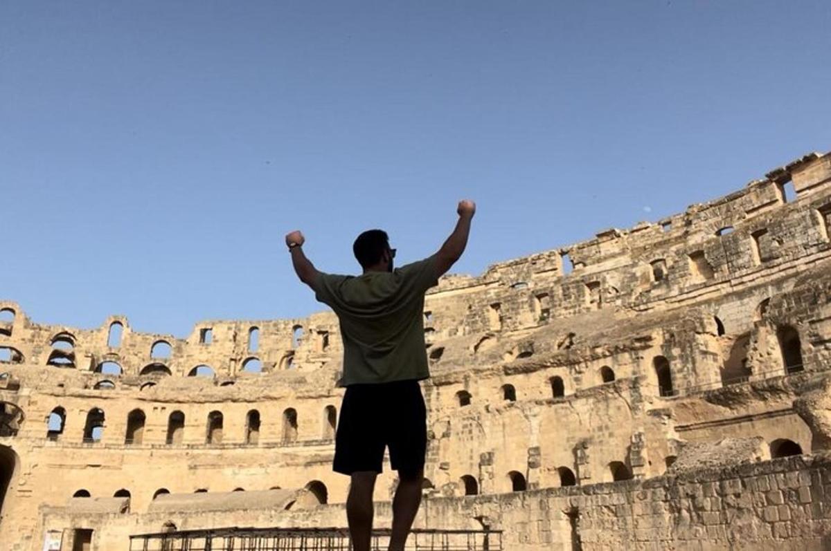a man standing in front of the coliseum
