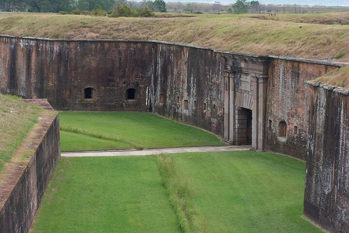 un vecchio castello con un campo verde di fronte