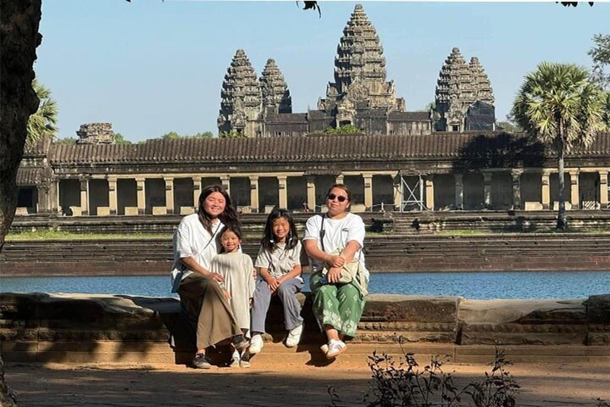 una famiglia seduta su una panchina davanti a un tempio
