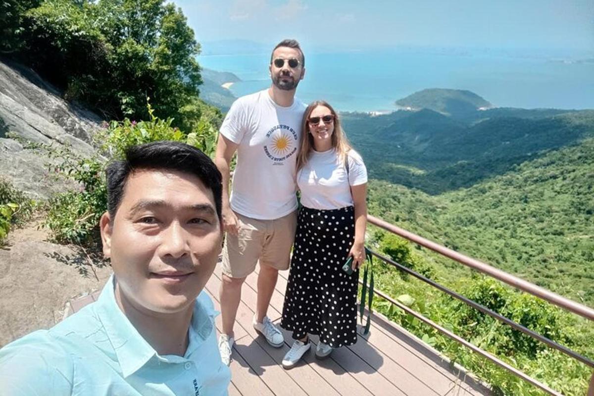 moški in ženska pozirata za sliko na vrhu gore