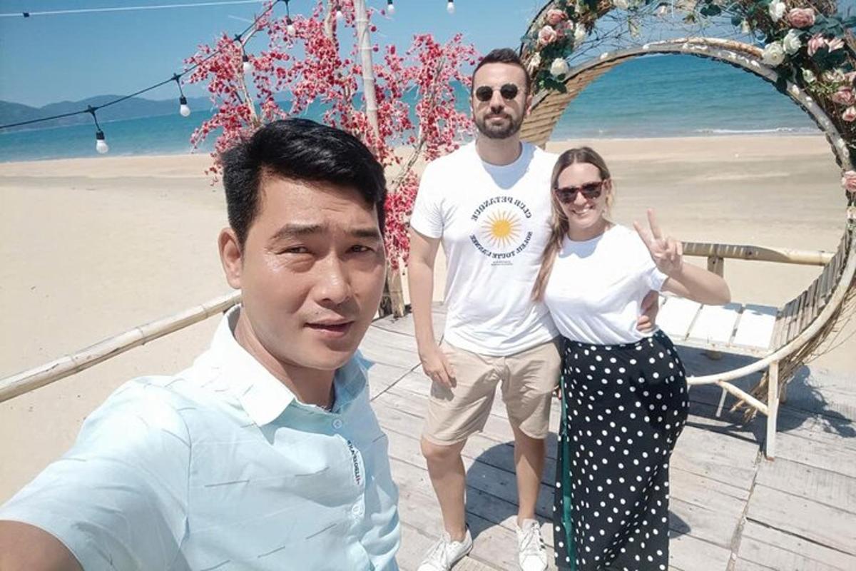 twee mannen en een vrouw staan op het strand