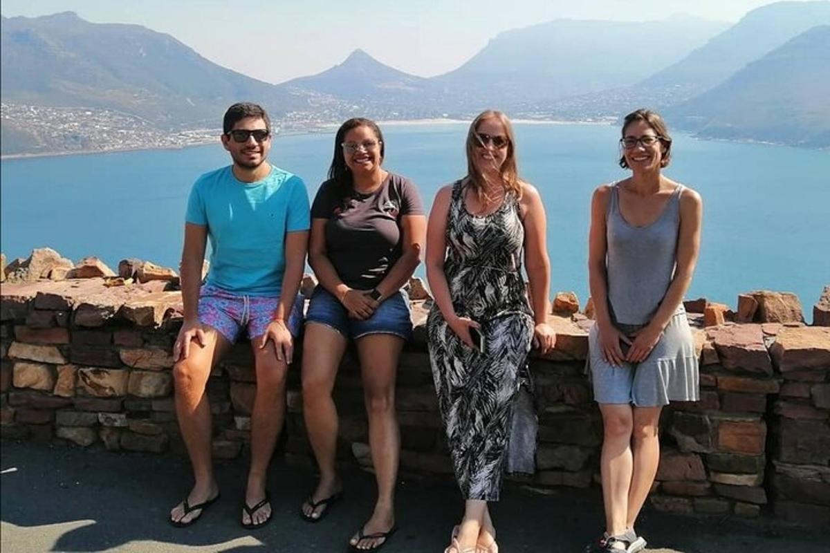 Un grupo de personas sentadas en un muro cerca del agua.