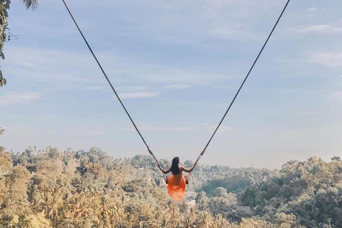 uma mulher de vestido laranja balançando em uma tirolesa