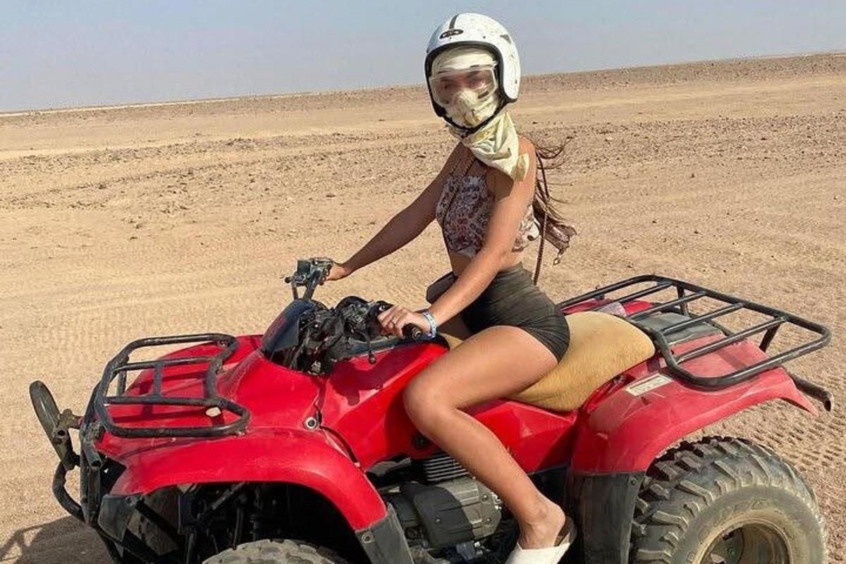 Naine istub kõrbes punasel ATV-l