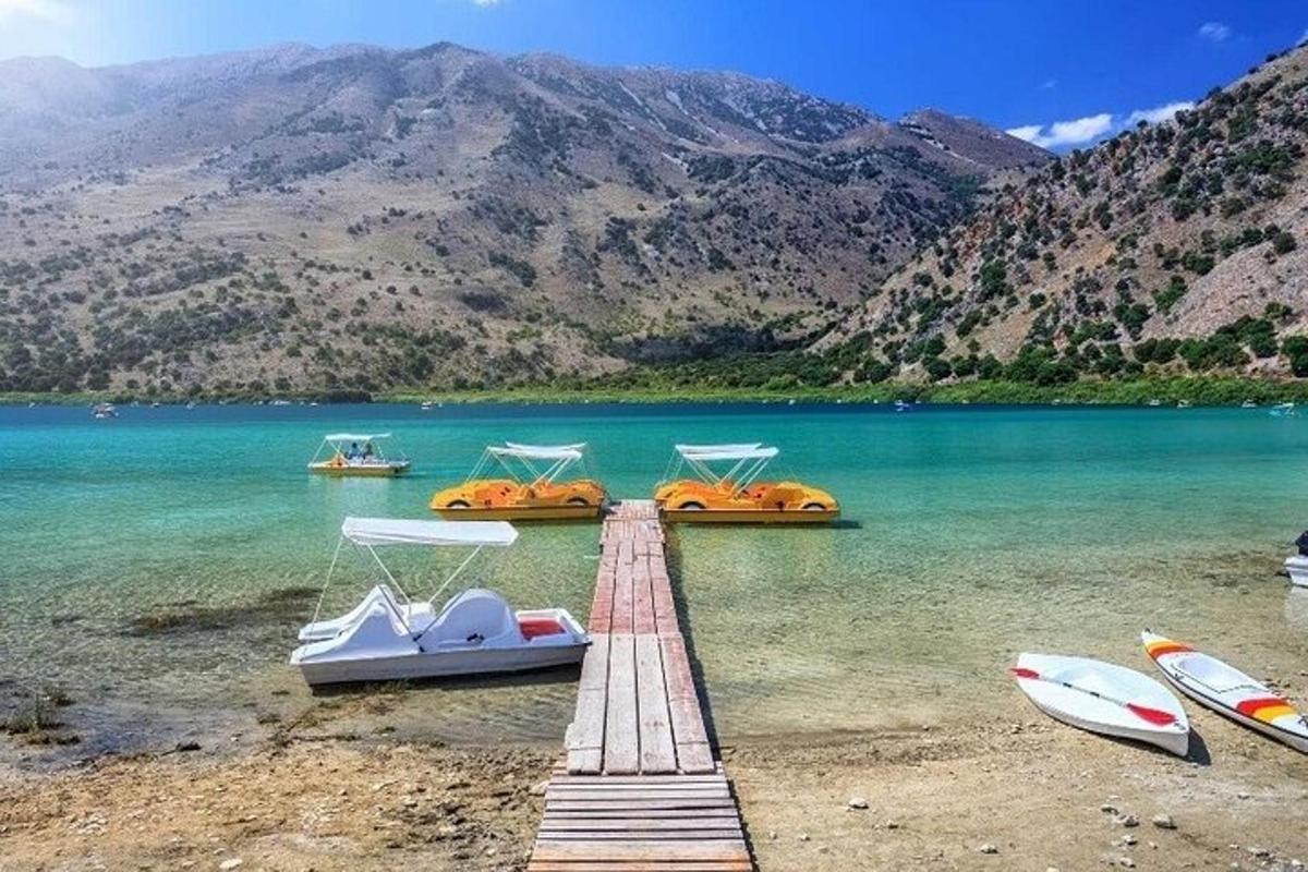 μια αποβάθρα με βάρκες σε μια λίμνη με βουνά