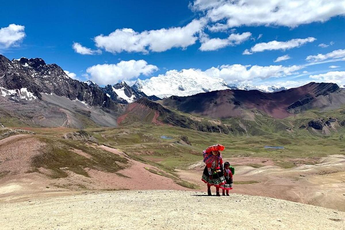 una donna e due bambini in piedi sulla cima di una montagna