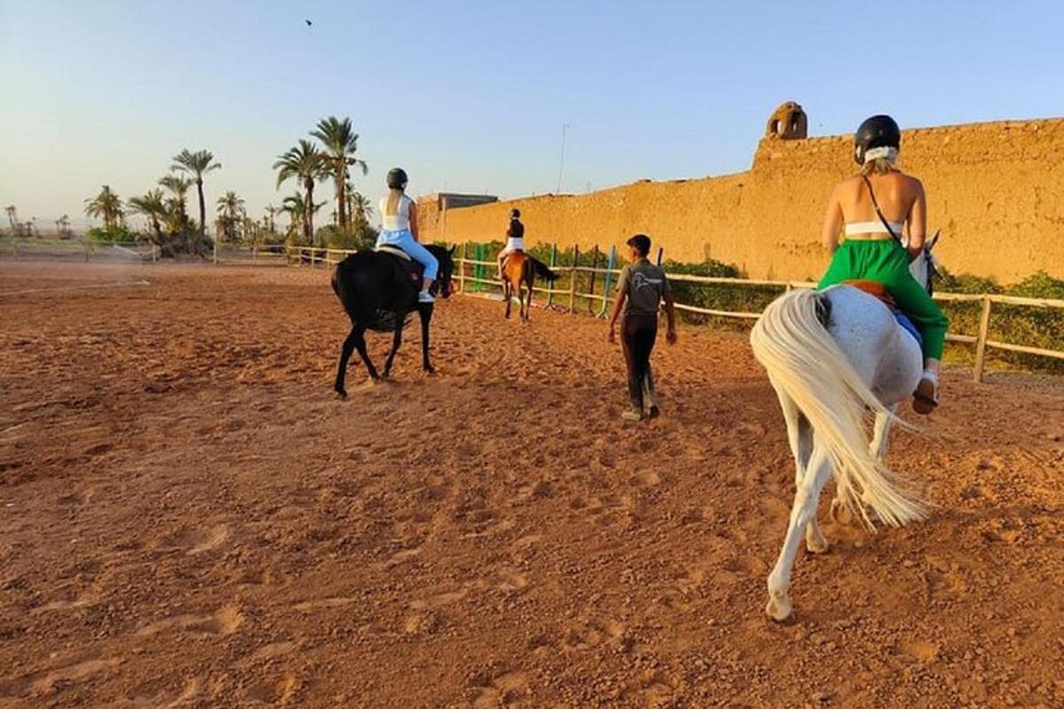 a group of people riding horses on a dirt field