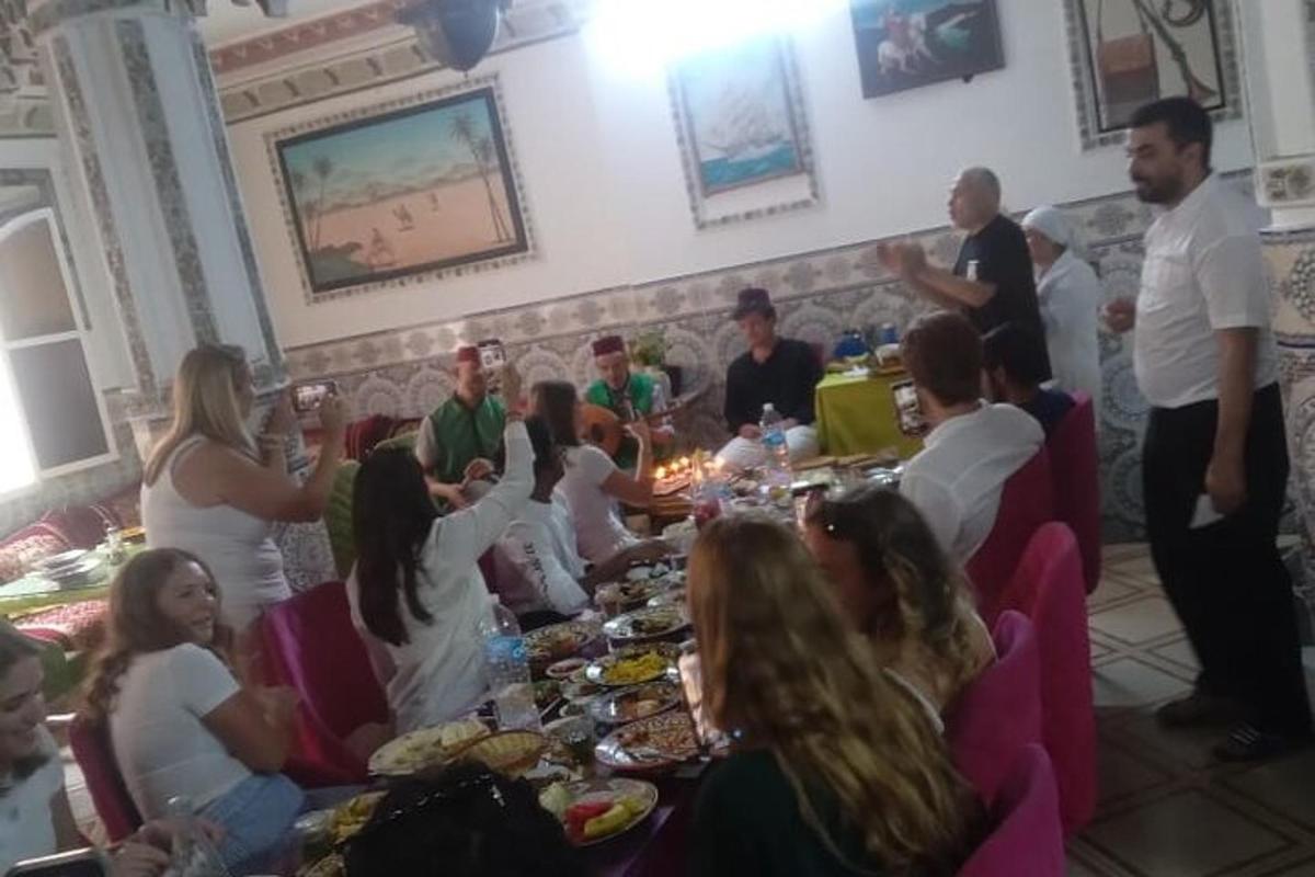 skupina ľudí sediacich okolo stola s jedlom