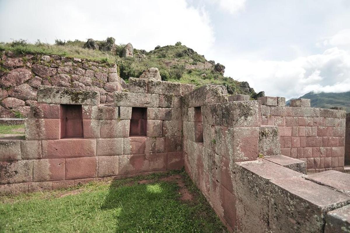 um antigo edifício de pedra com uma colina ao fundo