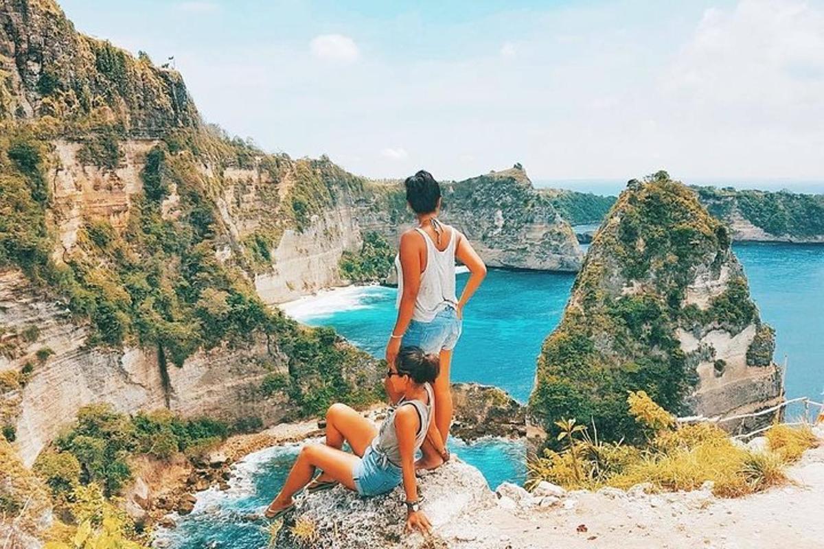 hai người đứng trên một tảng đá nhìn ra đại dương