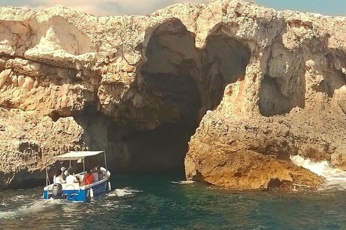 un grup de persones en una barca davant d'una cova