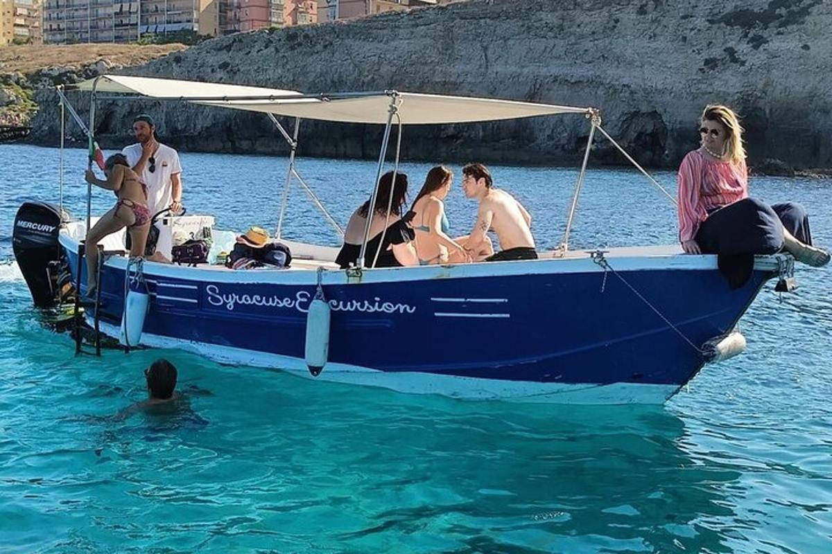 un grup de persones assegudes en un vaixell blau a l'aigua