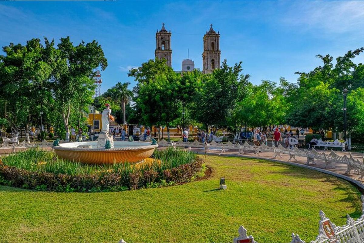 isang fountain sa isang parke na may dalawang tore sa background