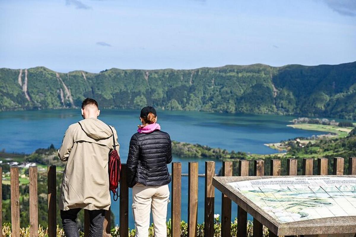 muž a žena stojící na plotě a dívající se na jezero