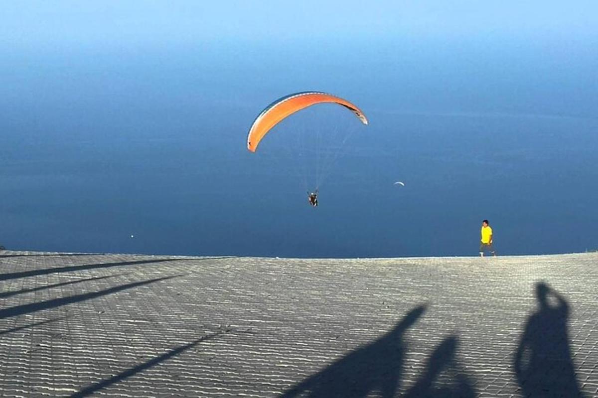 osoba pouštící draka na vrcholu kopce