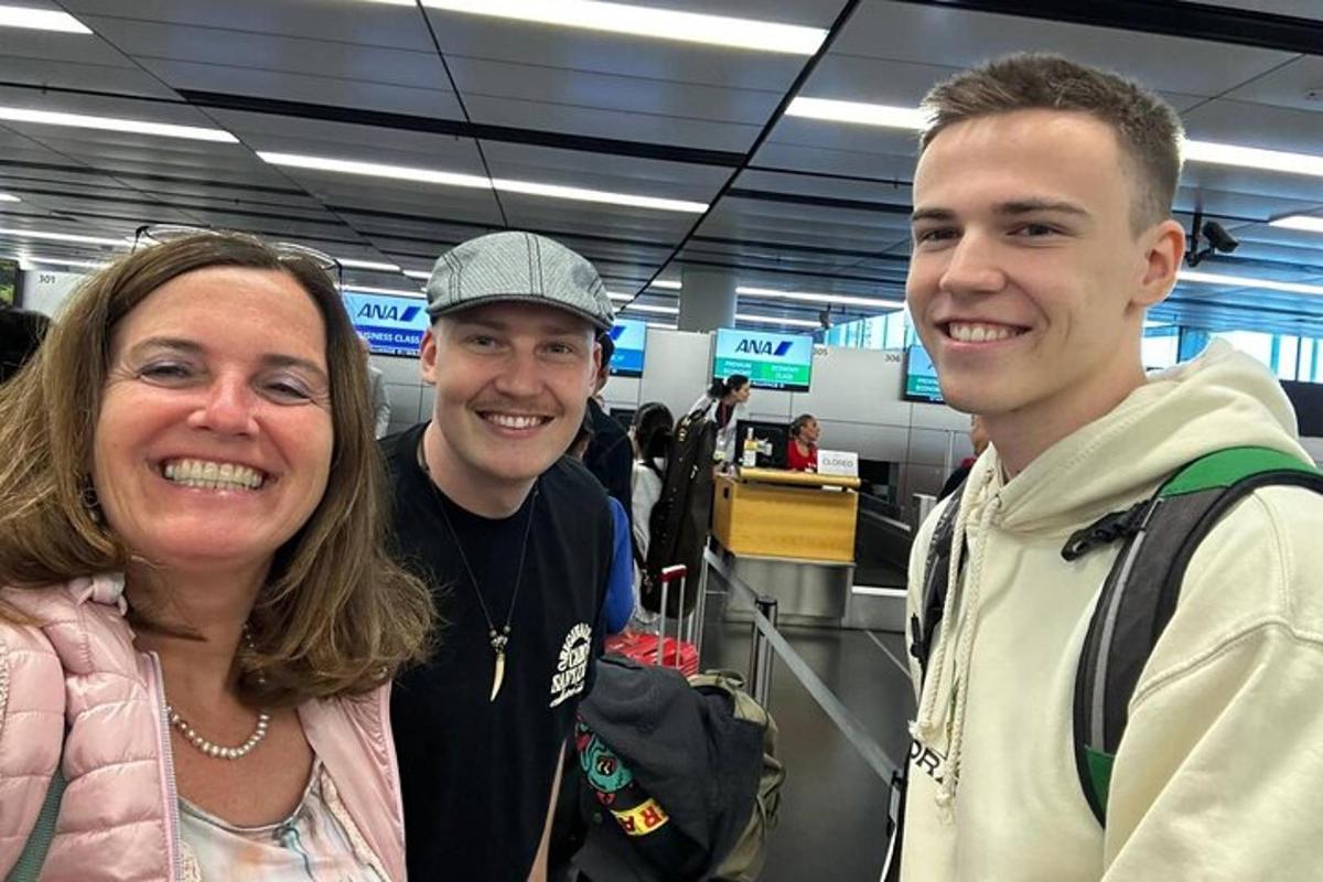 dois homens e uma mulher posando para uma foto em um aeroporto