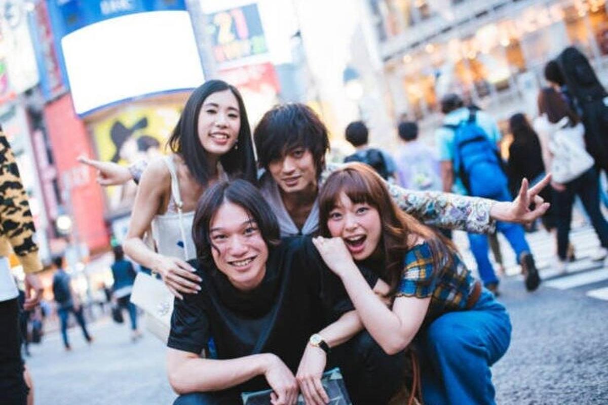 a group of people posing for a picture on a street