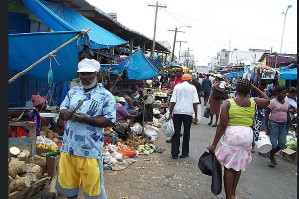 a group of people walking through an outdoor market
