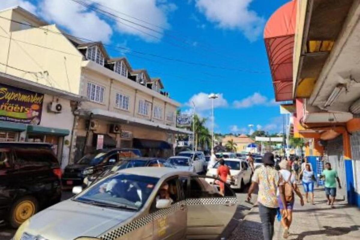 skupina lidí jdoucích po rušné ulici s auty