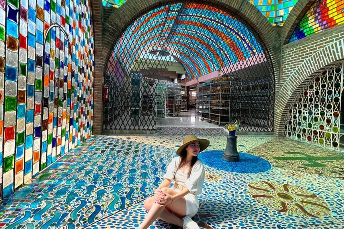 una donna seduta sul pavimento in una stanza con mosaici