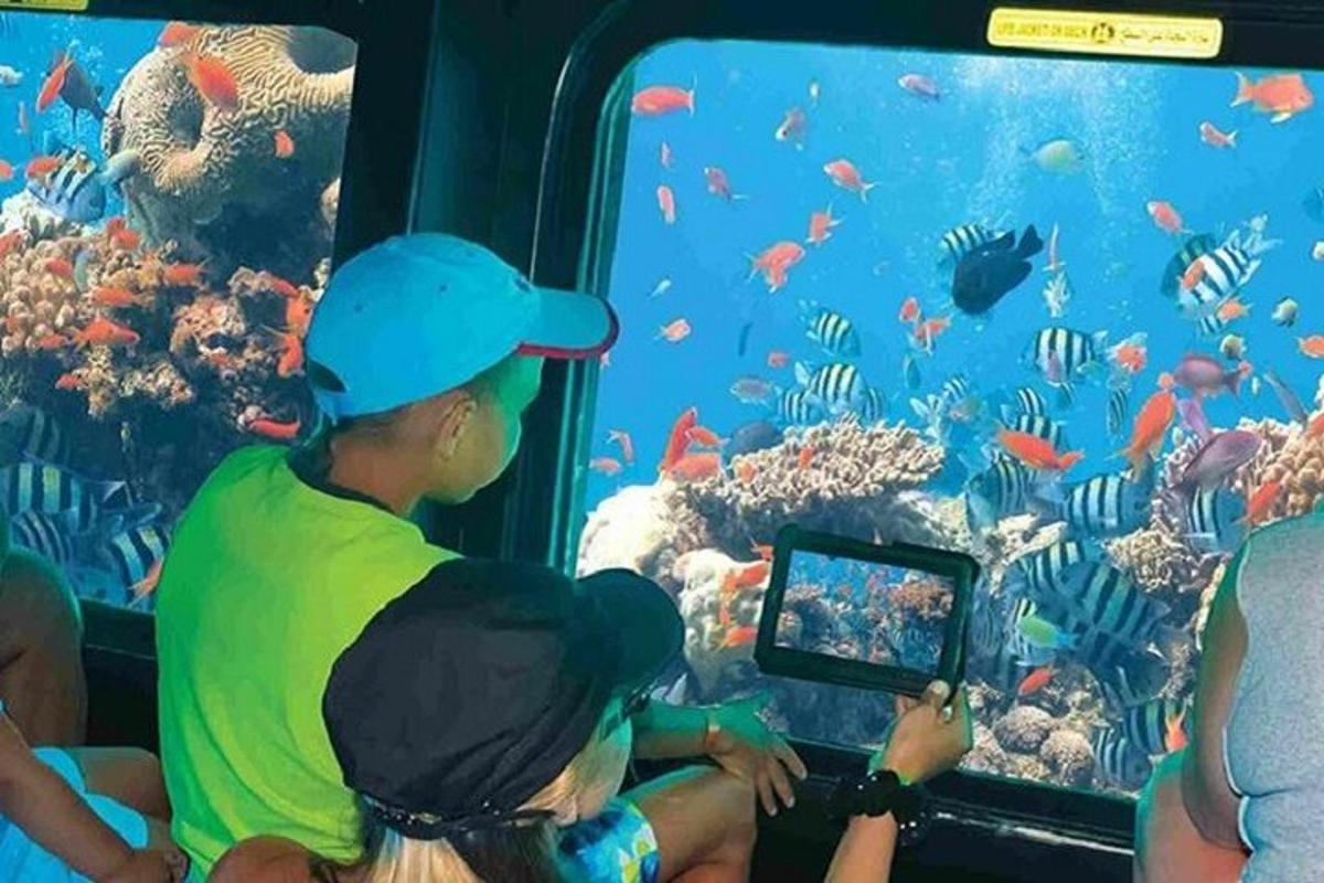 Un grupo de personas mirando peces en un acuario.
