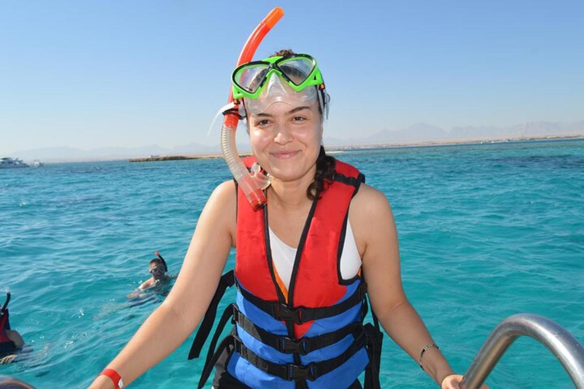 uma mulher usando um colete salva-vidas e óculos de proteção em um barco na água