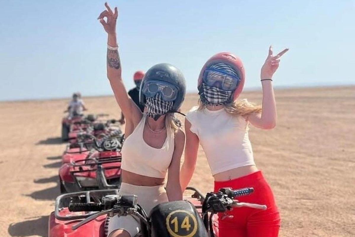 dua wanita berdiri di sebelah sekumpulan motosikal di padang pasir