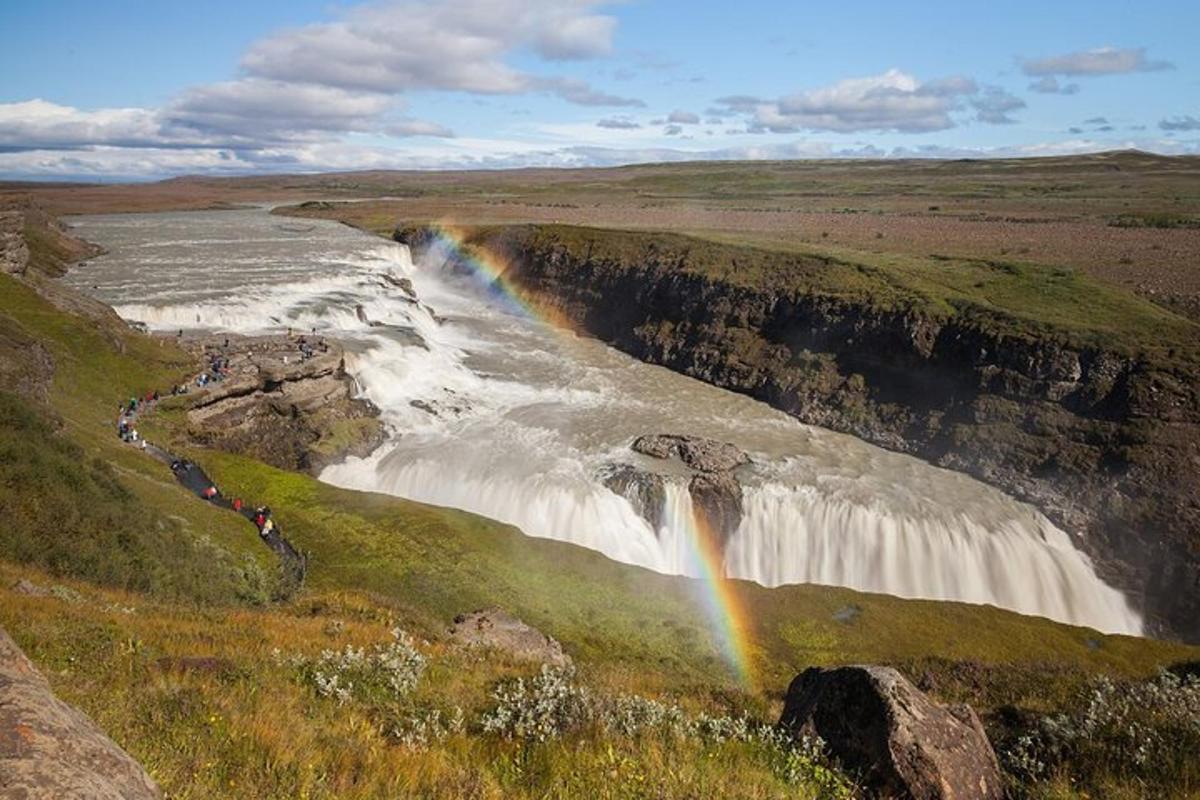un arcobaleno sopra una cascata in mezzo a un campo