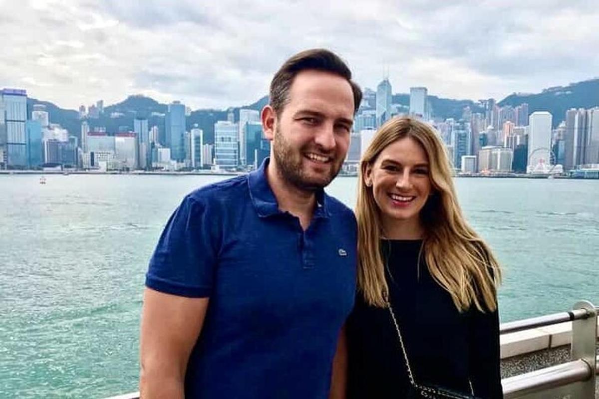 un uomo e una donna in piedi di fronte a una città
