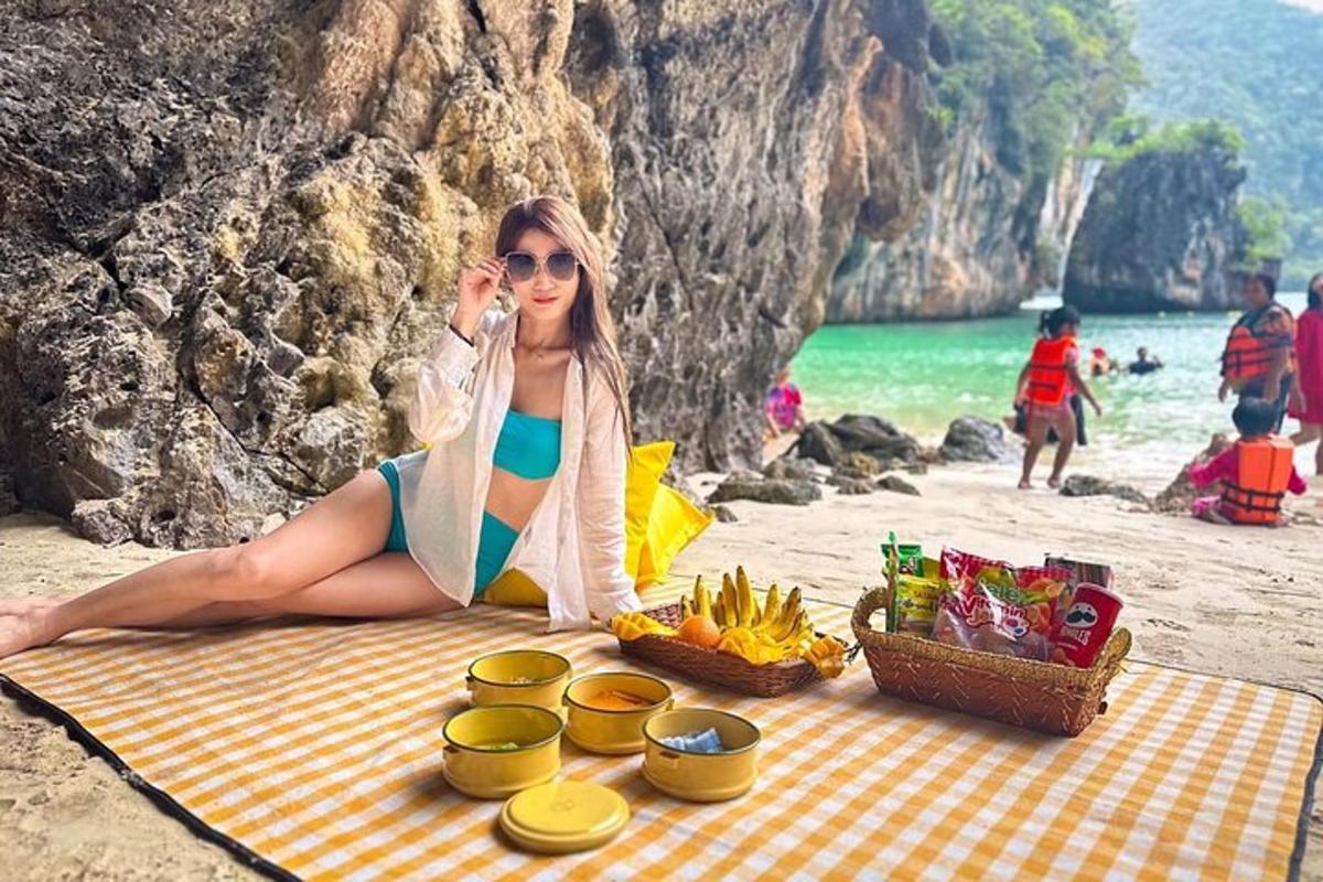 ženska sedi na plaži in se pogovarja po mobilnem telefonu