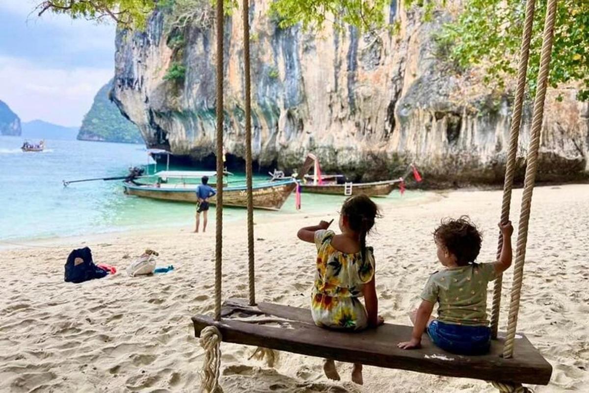 ビーチのブランコに座っている2人の子供