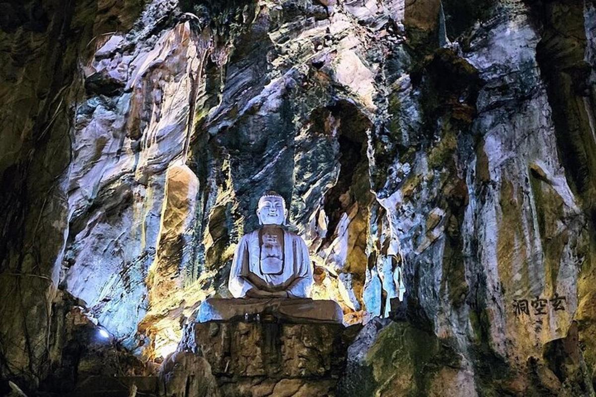 uma estátua sentada em uma rocha em uma caverna