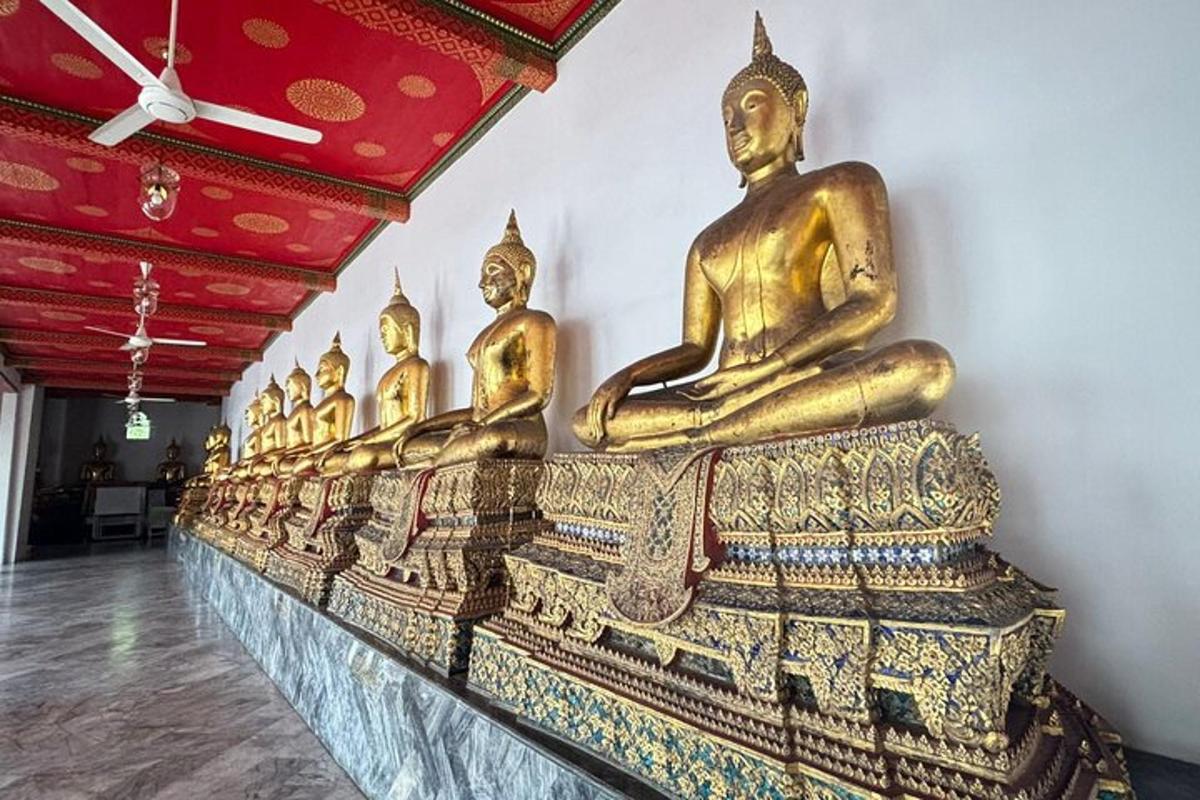 en række gyldne buddha-statuer i et rum
