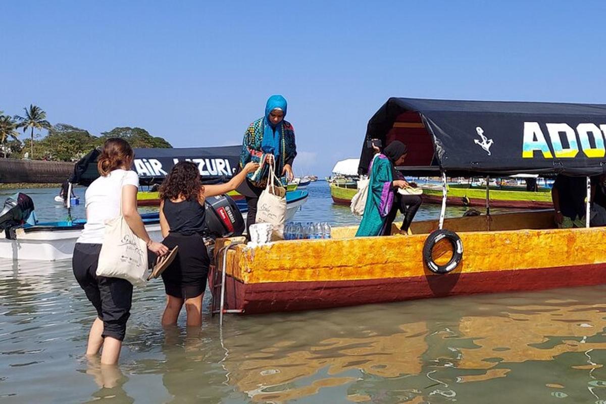 a group of people standing in the water next to a boat
