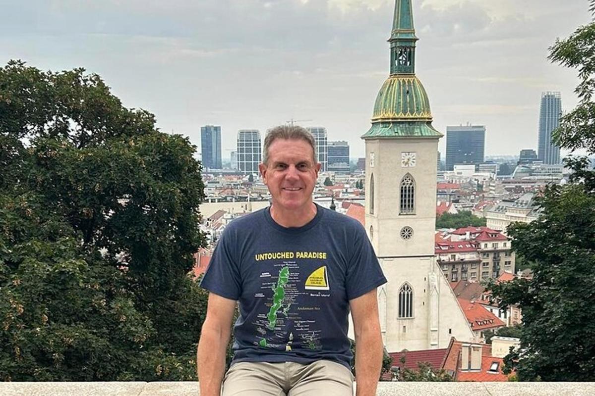 un uomo seduto su una sporgenza di fronte a una chiesa