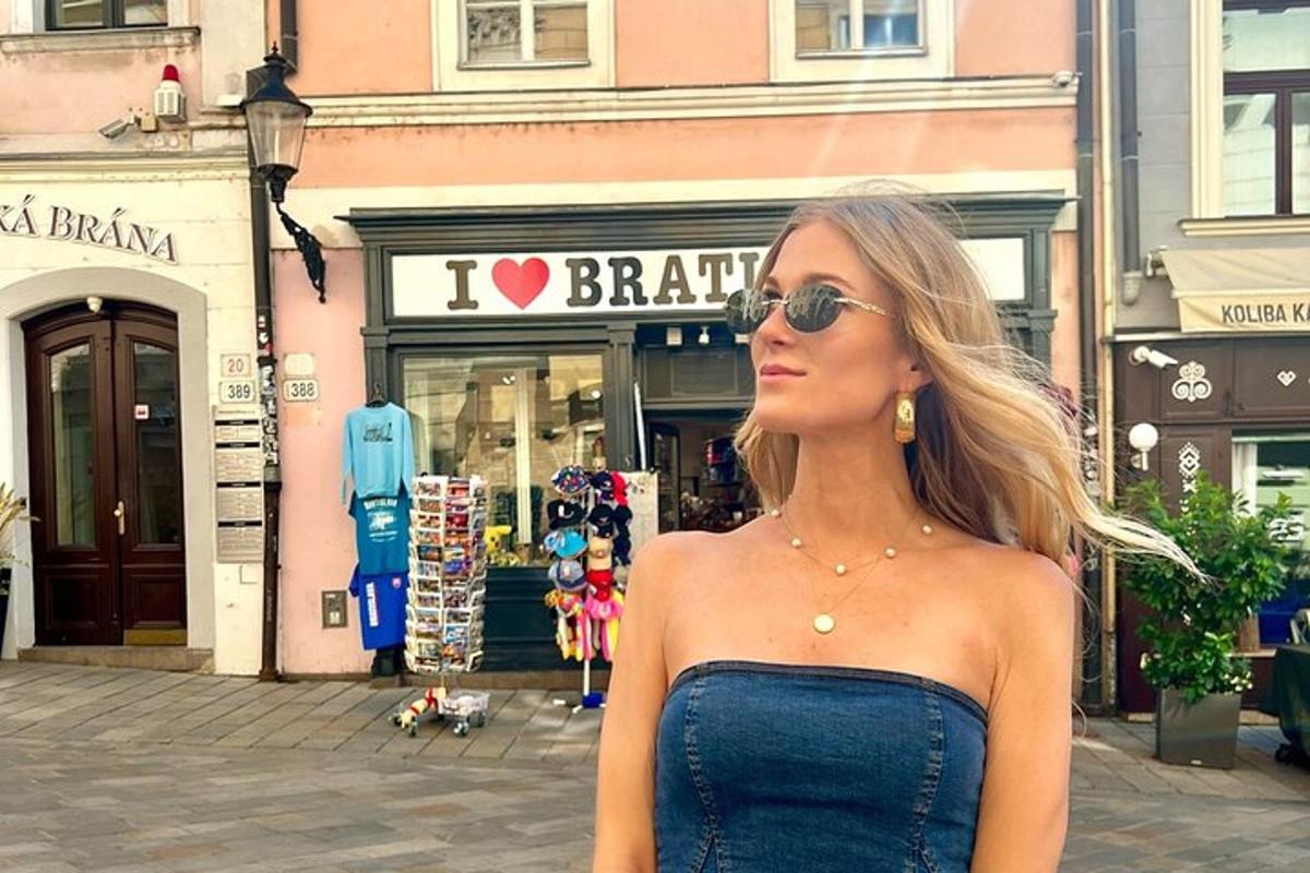 una donna con occhiali da sole in piedi davanti a un negozio
