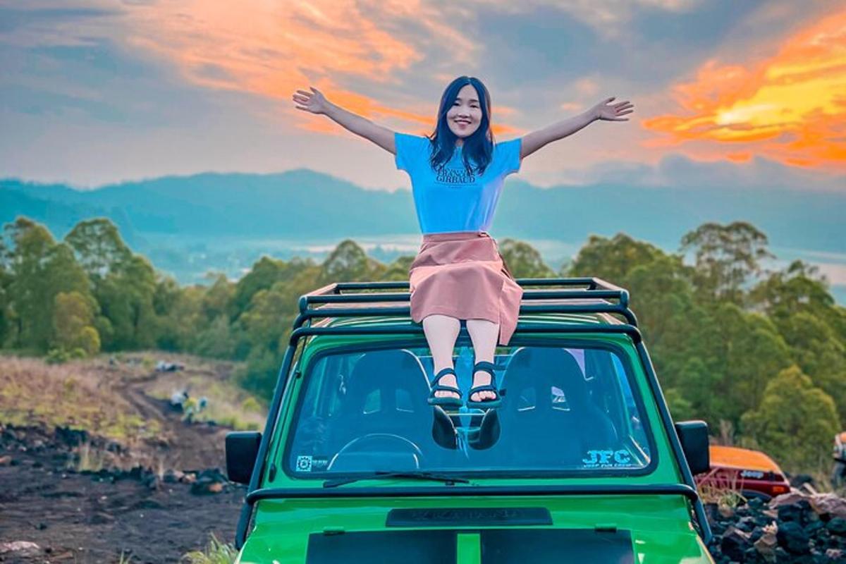 a woman is sitting on the roof of a car