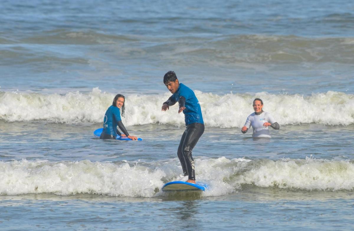 en mann som rir på en bølge på et surfebrett i havet
