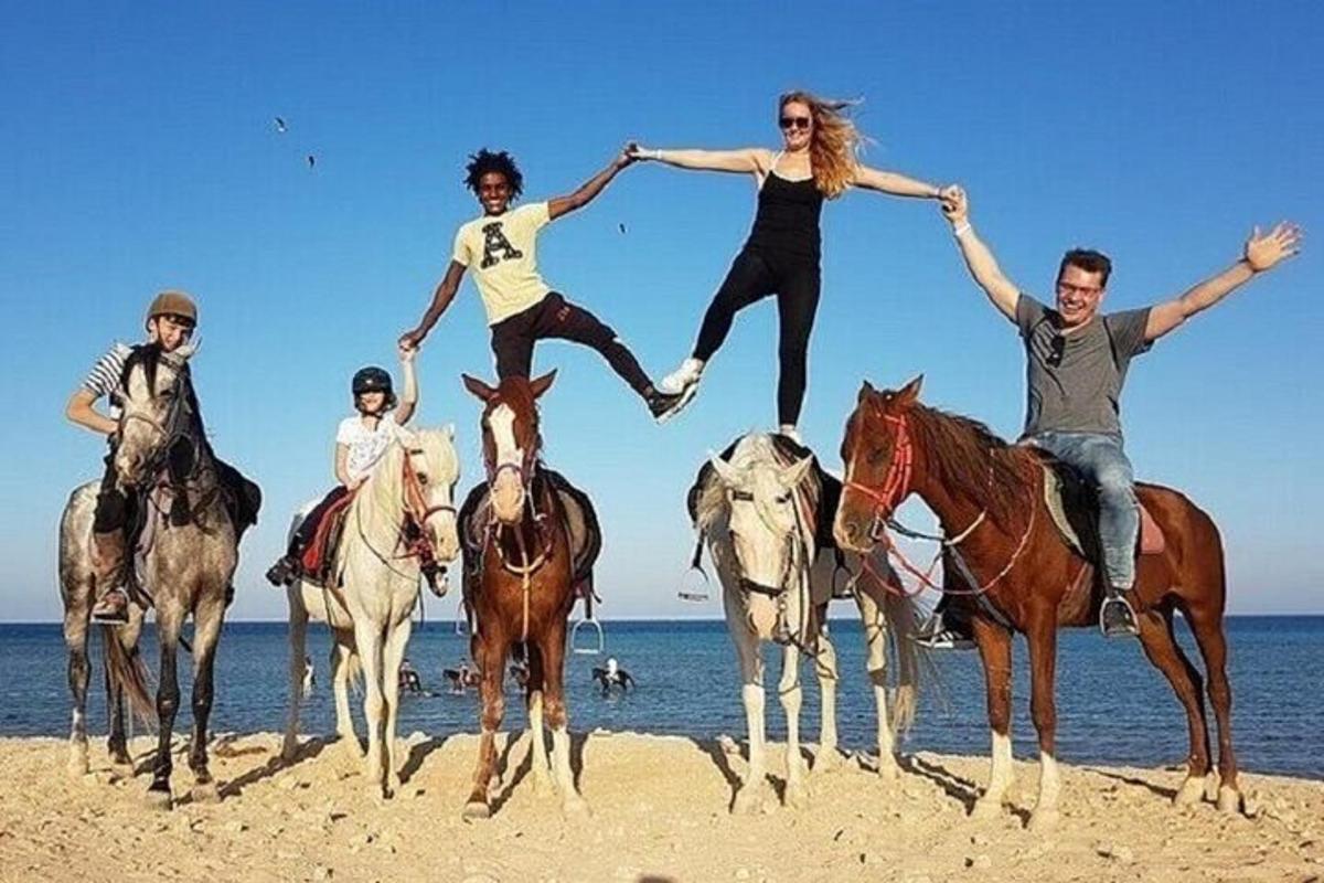 un gruppo di persone a cavallo sulla spiaggia