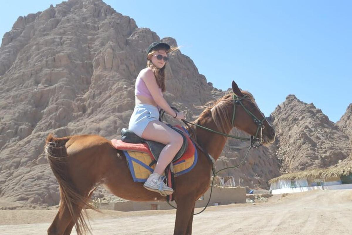 una donna a cavallo sulla spiaggia