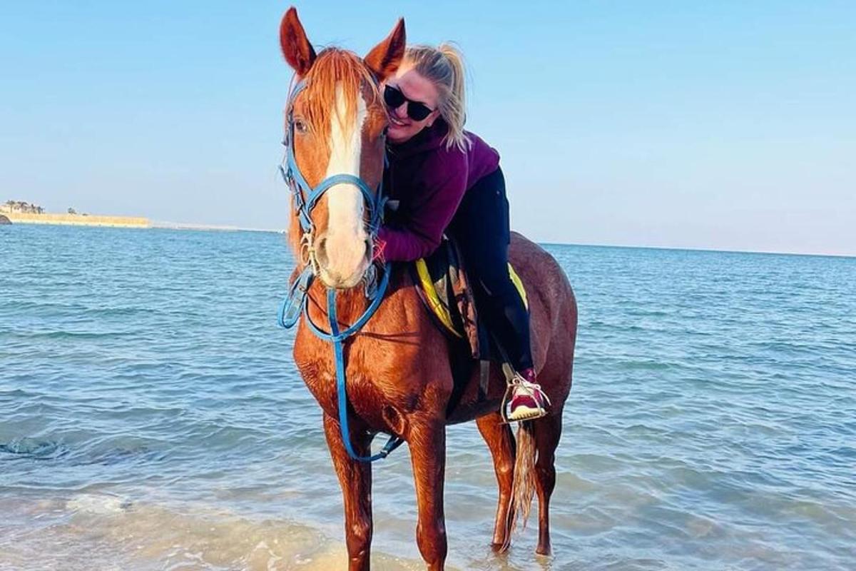 una donna a cavallo sulla spiaggia