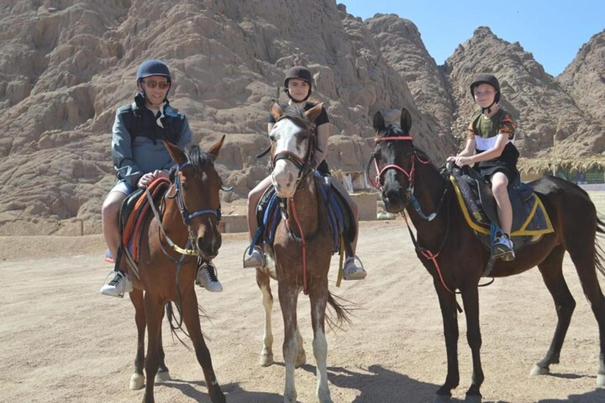tre persone a cavallo nel deserto