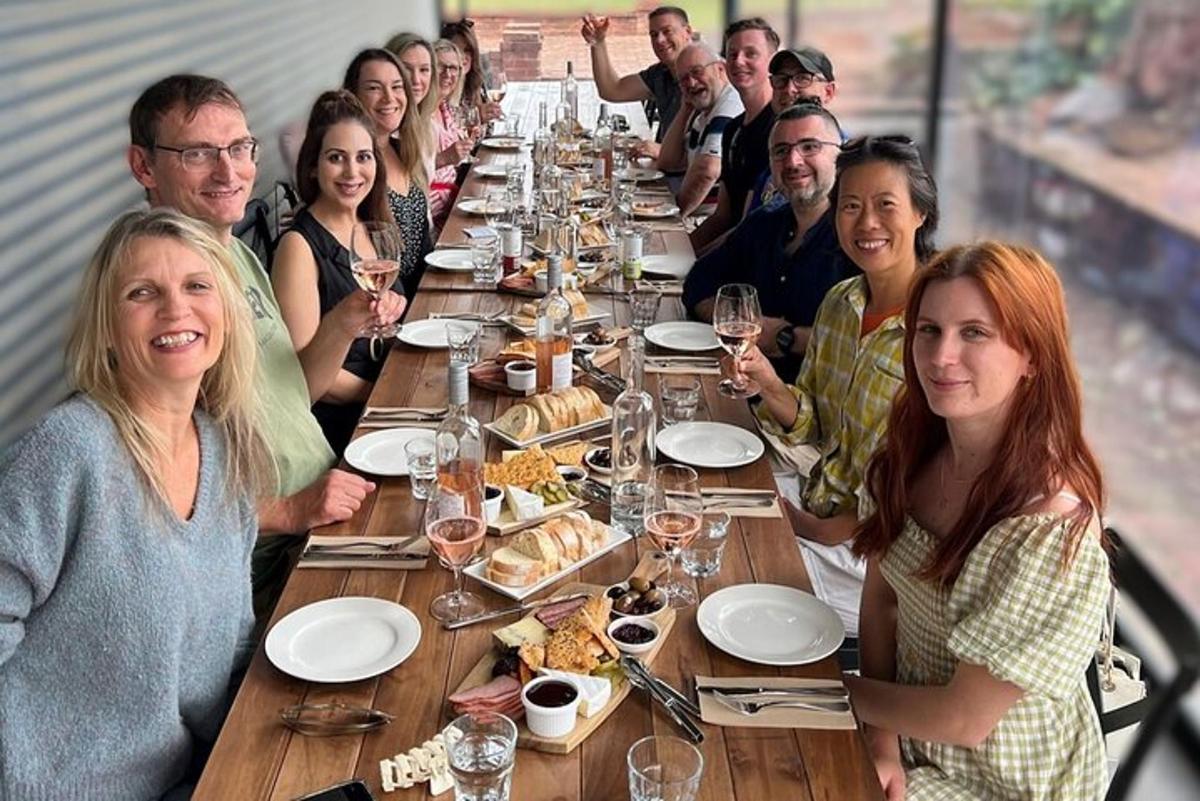 a group of people sitting at a long table with wine glasses