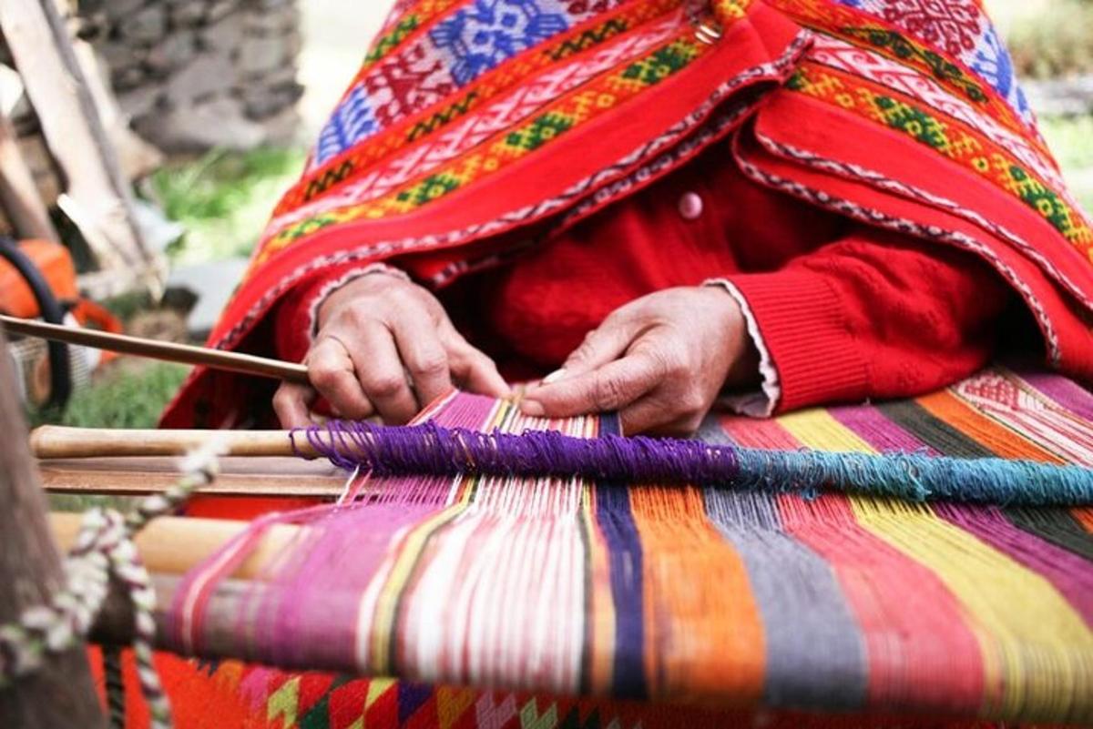 a person is knitting a piece of cloth with a stick