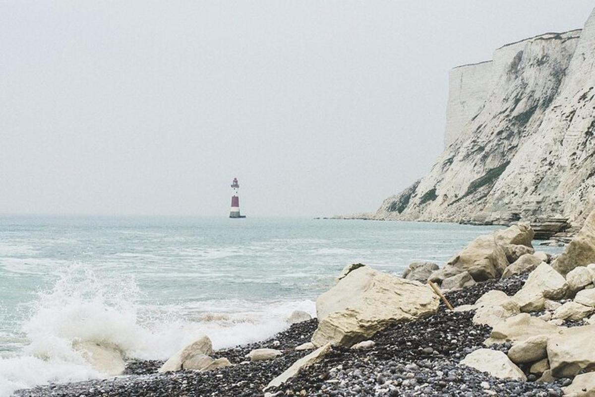 a lighthouse on a rocky beach with the ocean