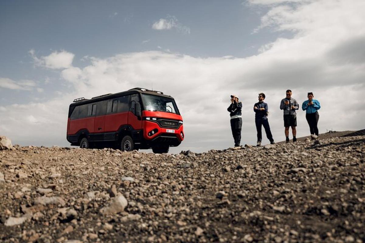 a group of people standing next to a red bus
